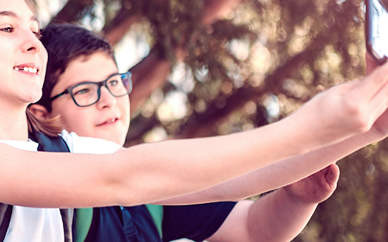 Kinder halten ein Smartphone und fotografieren sich. Kinder halten ein Smartphone und fotografieren sich.